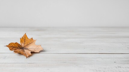 Poster - Single Dried Autumn Leaf Resting on a Light Wooden Surface in Minimalist Modern Interior Design : Generative AI