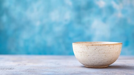 Leinwandbilder - Simple yet beautiful ceramic bowl placed against a textured blue background for an artistic touch : Generative AI