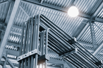 Leinwandbilder - A series of metal pipes are suspended from the ceiling. The pipes are connected to each other and appear to be part of a larger system. Concept of industrial organization and complexity