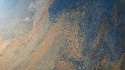 Fototapete - A rocky surface with a blue and brown color scheme. The surface is rough and uneven, giving it a rugged appearance. The blue and brown colors create a sense of depth and contrast