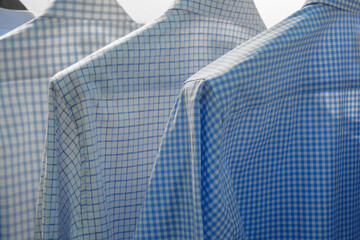 Aufkleber - Three blue and white plaid shirts hanging on a rack. The shirts are all different shades of blue and white