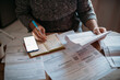 © Anna - Close-up of men's hands with a calculator and utility bills. The concept of rising prices for heating, gas, and electricity. Lots of utility bills and hands with a calculator and a notebook