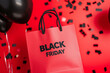 © JuananSH - bolsa de compras de papel rojo con la inscripción negra del título 'BLACK FRIDAY', fondo rojo, confeti negro y globos