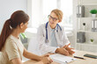 © Studio Romantic - Young female doctor physician or cardiologist in white coat with stethoscope around her neck smiling while talking to woman patient in medical office. Professional consultation and friendly atmosphere