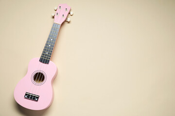 Wall Mural - One ukulele on beige background, top view. Space for text