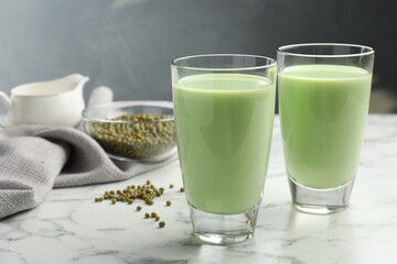 Wall Mural - Fresh mung bean juice in glasses and seeds on white marble table