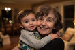© Алла Косач - Grandmother joyfully embraces her smiling grandson in a cozy indoor setting during a family gathering