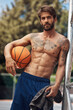 © peopleimages.com - Sports, basketball court and portrait of man with towel for match, practice and competition outdoors. Fitness, athlete and person with ball for training, playing game and exercise for performance