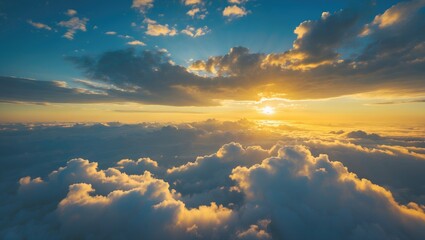 Wall Mural - Aerial perspective captures a stunning golden sunrise above thick white clouds against a blue sky.