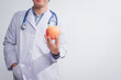 © R Photography - A male doctor stands holding an apple against a white background, promoting healthy eating educates patients on nutrition, wellness, disease prevention through a balanced diet and medical expertise