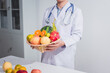 © R Photography - A male doctor stands holding an apple against a white background, promoting healthy eating educates patients on nutrition, wellness, disease prevention through a balanced diet and medical expertise