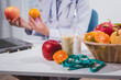 © R Photography - A male nutritionist works at his desk, discussing the benefits of eating fruit. He analyzes diets and educates patients on healthy eating habits for optimal health and well-being