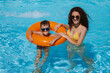 © alexkoral - happy young mother teaches child boy son to swim in swimming pool at a hotel on vacation at a resort in the summer