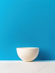 Aufkleber - Artisanal Porcelain Bowl on Textured White Shelf Against Bold Blue Background Contemporary Home Decor Inspiration for Interior Design and Retail Styling