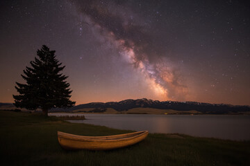 Wall Mural - A canoe is sitting on the grass next to a lake