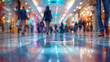 © Duka Mer - Close-up view from floor level in a busy mall with people strolling, showing blurred motion and a bokeh effect.