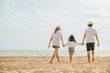 © sorapop - Happy Asian parents with their daughters enjoying playful at beach. Little girls with their mother and father holding hand of child walking on sand beach. Positive family outdoor activity