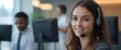 © Pod - A young woman working as a call center operator wearing headphones and holding a microphone