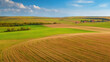 © Bonsales - Aerial view of a striking moravian landscape split between golden rapeseed fields and lush green farmland with perfect symmetry and long tree shadows at sunset