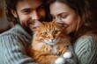 © ChaoticMind - Couple embraces their orange tabby cat in cozy sweaters during a warm indoor gathering at home