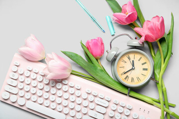 Wall Mural - Alarm clock with tulip flowers and keyboard on white background