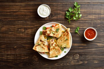 Wall Mural - Chicken quesadilla with fresh vegetables on wooden table