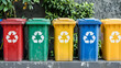 © rizkan - Colorful recycling bins lined up against a textured wall with greenery in the background