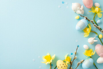 Wall Mural - Festive Easter composition featuring pastel eggs, yellow daffodils, and ceramic bunnies on a soft blue background, perfect for seasonal and holiday-themed projects