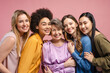 © Maria Vitkovska - Happy diverse women embracing senior woman on pink background