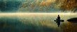 © Ai Studio - A lone figure meditates on a rock beside misty waters, surrounded by autumn's golden forest, embodying peaceful solitude and harmony.