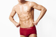 © SHOTPRIME STUDIO - Confident young man with toned physique posing in red swimwear, showcasing athleticism and strength. Fitness and lifestyle concept with a clean, minimalist background.