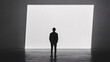 © alexandr - a solitary man in a dark room stands before a large glowing white panel casting a striking contrast between light and shadow