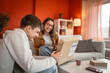 © Miljan Živković - Two friends boyfriend and girlfriend enthusiastically open the package