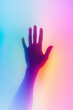 © Andres Mejia - Hand reaching out on vibrant rainbow gradient background