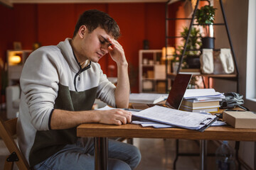 Wall Mural - exhausted tired man student try to study for exams at home