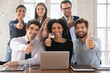 © fizkes - Six enthusiastic motivated multinational teammates showing thumbs-up to camera, gesture of best services, feedback, celebrate career growth and promotion. Symbol of approval, agreement, encouragement
