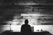 © Canvas - Person silhouetted at desk working on laptop in front of wood wall.