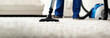 © Vladislav - Professional carpet cleaning service in a modern apartment, showing a worker using a high-end vacuum cleaner on a plush living room carpet