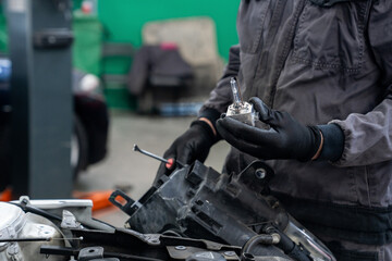 Poster - Serviceman repair headlight in car service