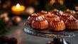 © midah - Close Up Of A Platter Of Beautifully Arranged Brown And Orange Baked Pastries With Candlelight