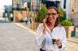 © Zamrznuti tonovi - Businesswoman walking talking on phone drinking coffee