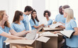 © Prostock-studio - Young volunteers group sorting clothing donations in cardboard boxes, copy space