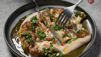 Canvas Print - chef cut with fork and knife freshly prepared cauliflower steak with beans puree and chimichurri sauce to show how delicious is healthy vegan meal, portion closeup