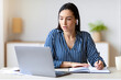 © Prostock-studio - Woman At Laptop Taking Notes Combining Work And Study Learning Sitting In Modern Office. Business Career. Selective Focus