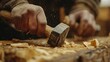 © kura - Man using a hammer to chisel wood for a woodworking project