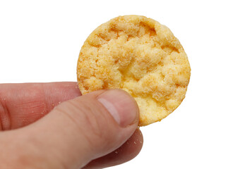 Wall Mural - A hand holding a small, round, yellow snack