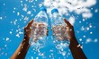 © Anuson - Two hands tightly holding water bottles with bubbles floating in the air against a bright backdrop