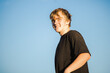 © Austockphoto - Portrait of teenage boy isolated on blue sky background