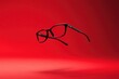 © MrHamster - Black Eyeglasses Are Floating In Front of a Red Background