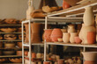 © Austockphoto - Diverse handcrafted pottery on rustic shelves in a workshop